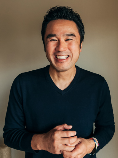 Fotoportræt af Tetsu, som kigger på læseren med et stort smil.
