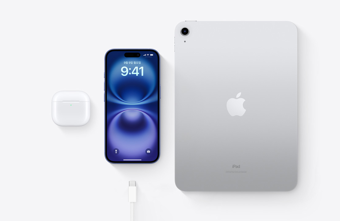 USB-C 커넥터를 갖춘 AirPods Pro, iPhone 16, iPad를 위에서 아래로 내려다본 시점을 통해 세 기기 모두 동일한 USB-C 케이블로 충전할 수 있음을 보여주는 모습.
