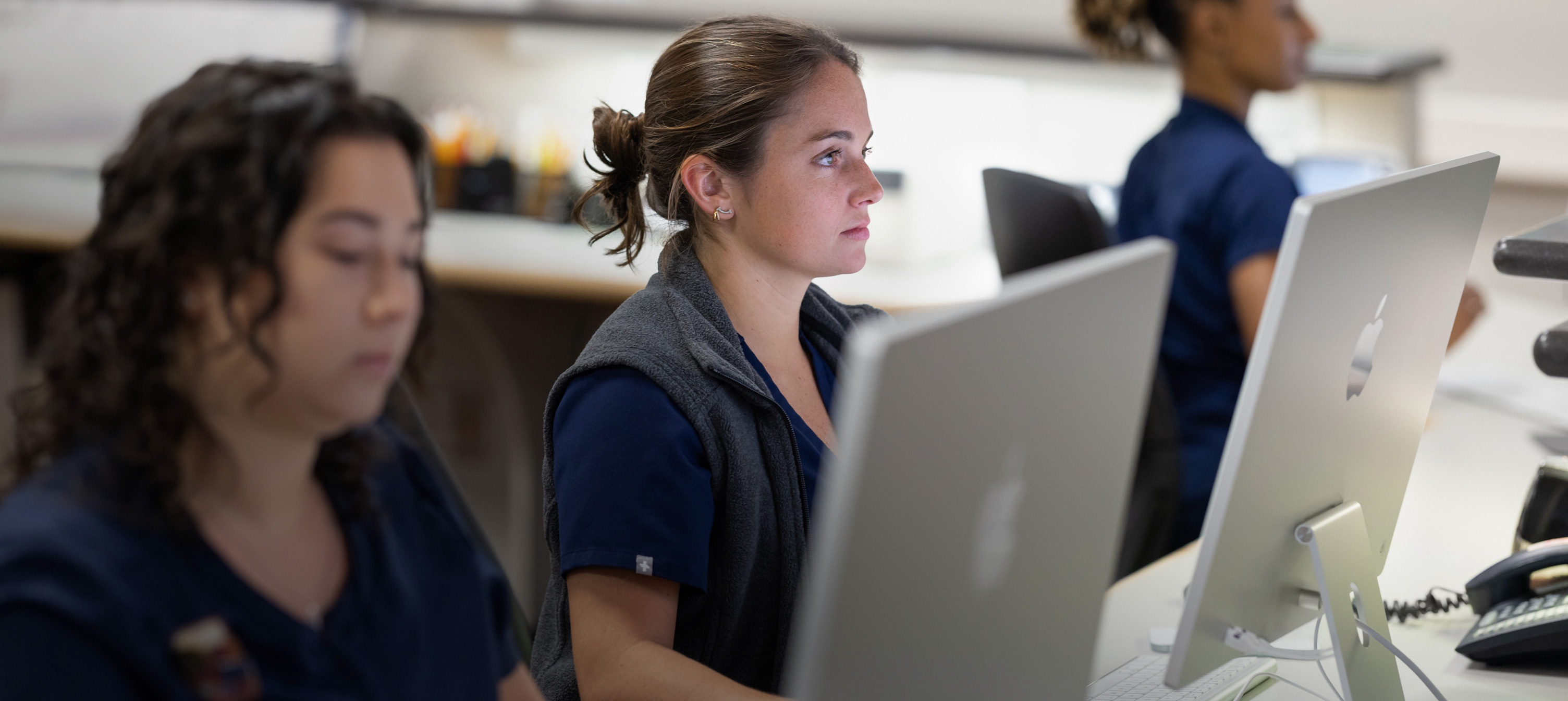 Tre infermiere che lavorano ai rispettivi iMac.