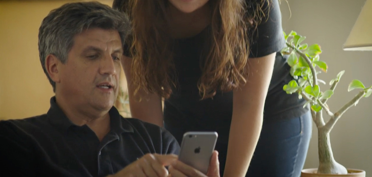 Un uomo che condivide le proprie informazioni sanitarie su un iPhone con la donna accanto a lui.