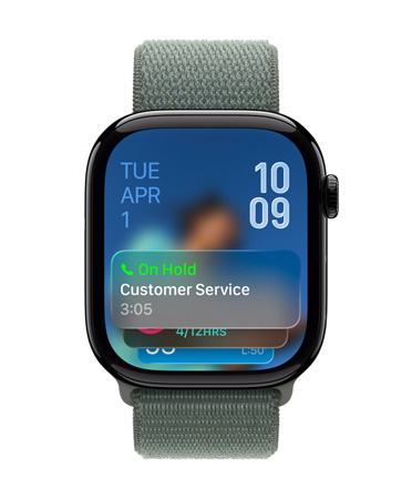 Apple Watch in Jet Black with Sage Band, Face shows Call Assistant notification at bottom, date on top left, time numerals stacked at top right