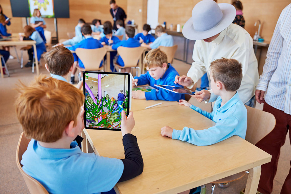 iPad ProとApple Pencilを使って作業する若いアーティストたちと交流する、アーティストのTin Nguyen。