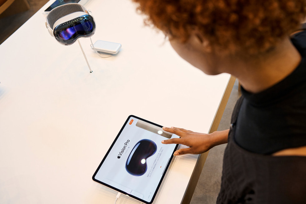 عميلة تتصفح معلومات حول Apple Vision Pro على جهاز iPad.