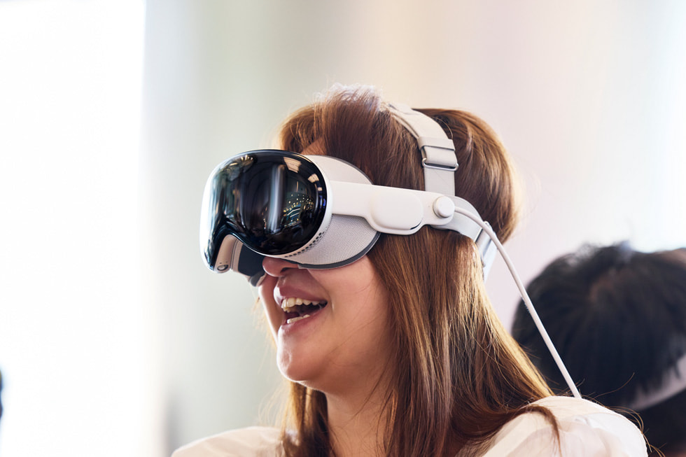 عميلة ترتدي Apple Vision Pro داخل متجر Apple Wangfujing وتحدق بالسقف بتعبير ينم عن الذهول.