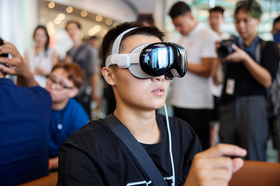 عميل يرتدي Apple Vision Pro ويضم اصبعيه معاً.
