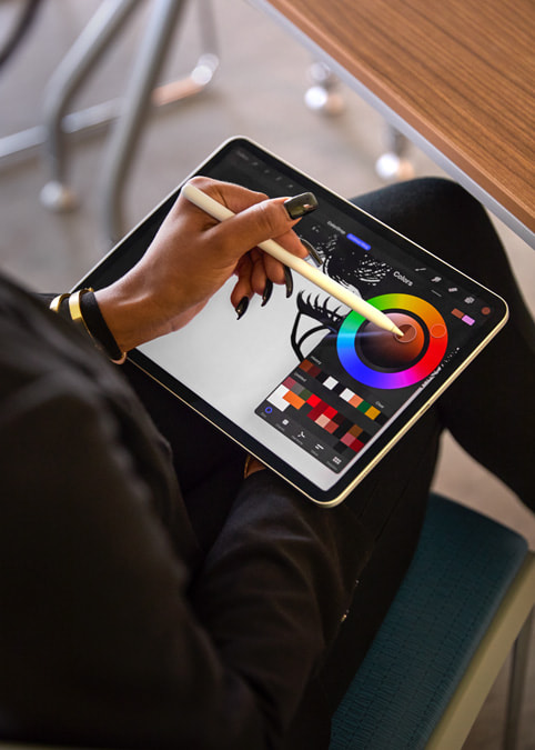 照片特寫 iPad Pro 螢幕，其中 Liza 使用《Procreate》和 Apple Pencil 進行創作。