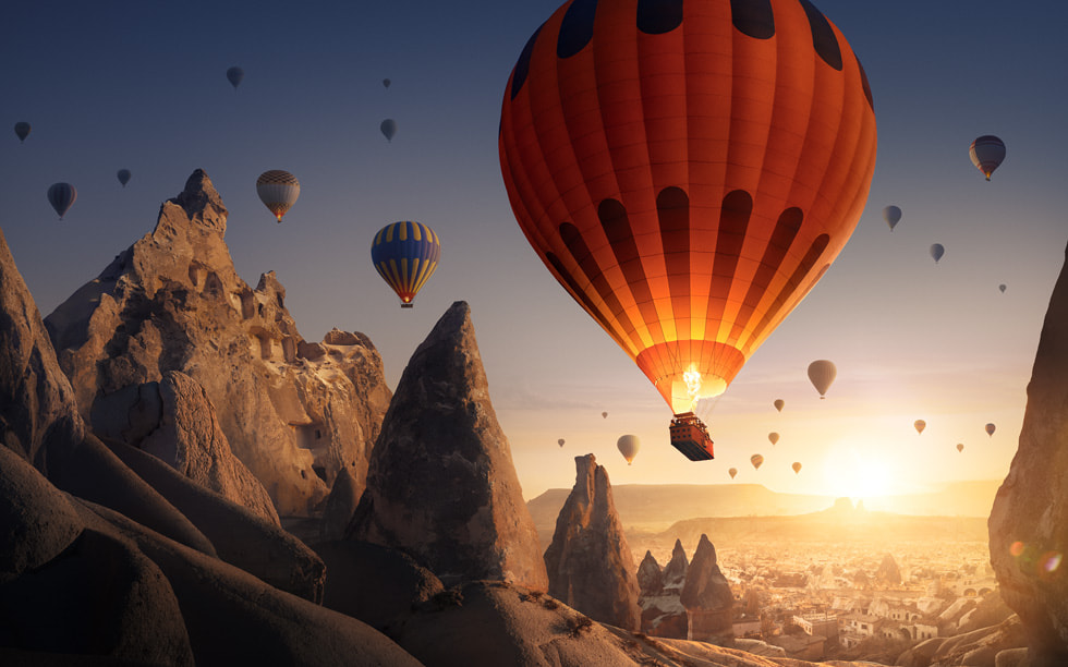 Une image de « Boundless » montre des montgolfières traversant un paysage montagneux.