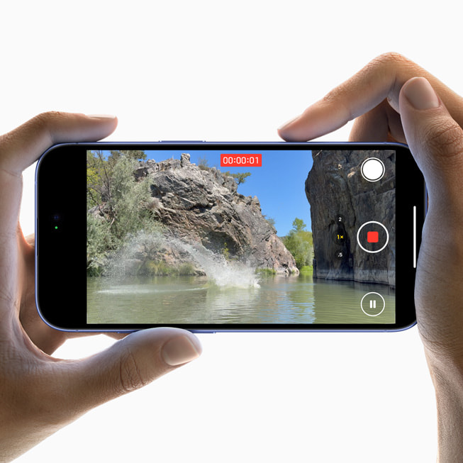 Iemand filmt een persoon met een blauwe sjaal op iPhone 16.