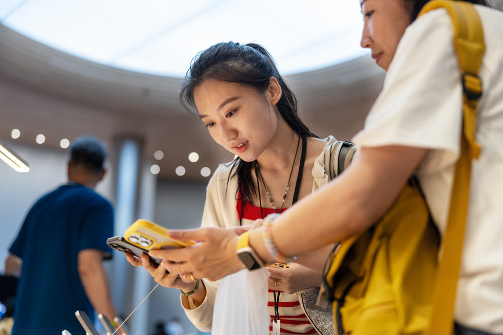 Deux clientes comparent le nouvel iPhone 16 Pro avec leur téléphone actuel.