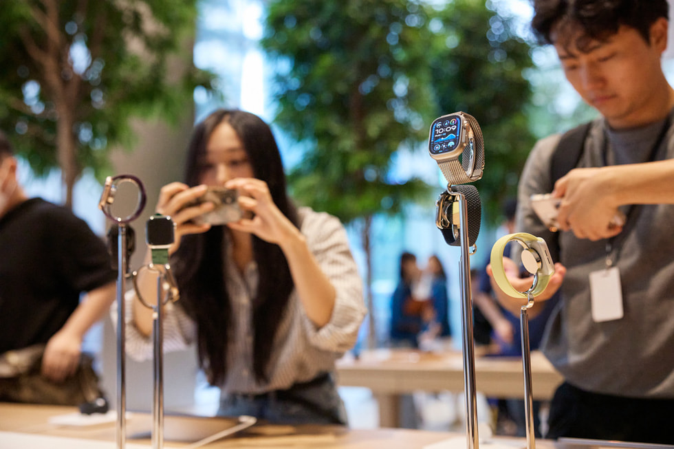 Des clients découvrent la nouvelle Apple Watch Ultra 2 en titane noir et les Bracelets Milanais en titane.