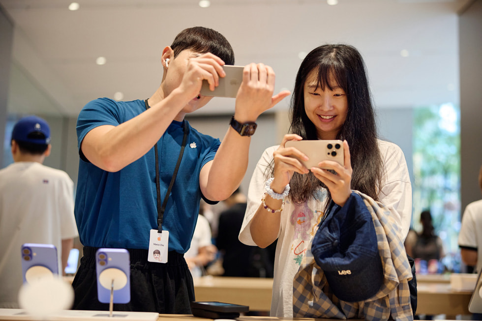 Une cliente et un employé essaient la nouvelle Commande de l’appareil photo sur l’iPhone 16 Pro.
