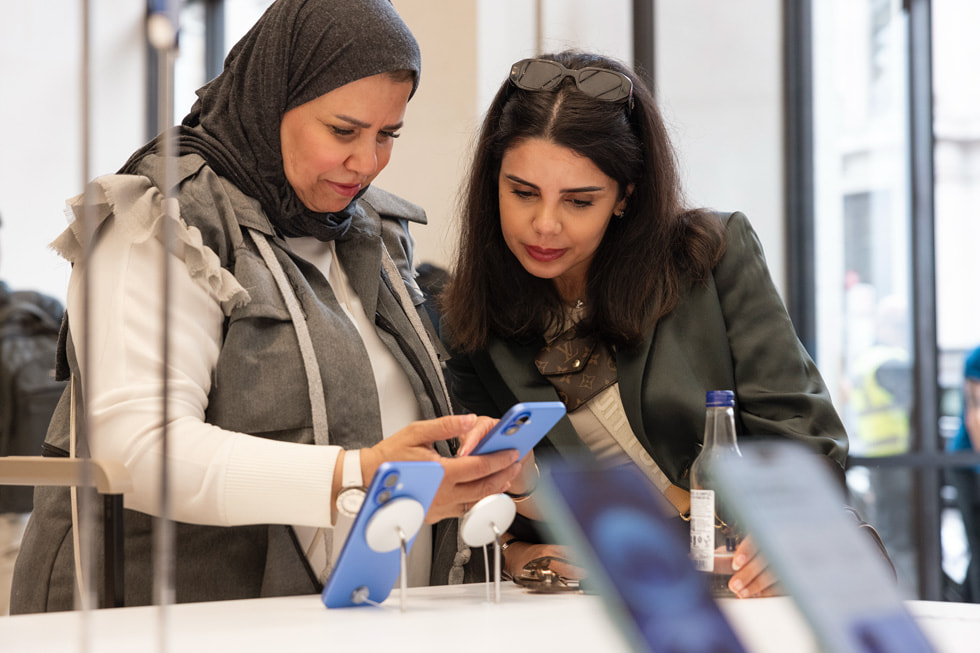 Deux clientes s’intéressent aux nouveaux iPhone 16 à Apple Regent Street, à Londres.