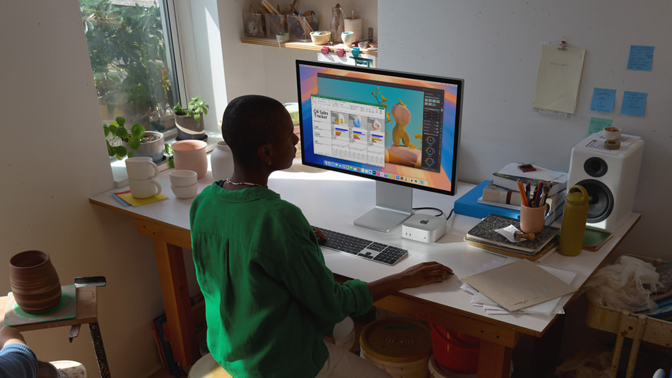 مستخدم Mac mini يعمل على مكتب محاط بقطع من السيراميك.