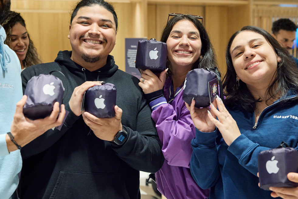 Khách hàng khoe những chiếc khăn trải dã ngoại kỷ niệm Apple Miami Worldcenter tại cửa hàng Apple Miami Worldcenter.