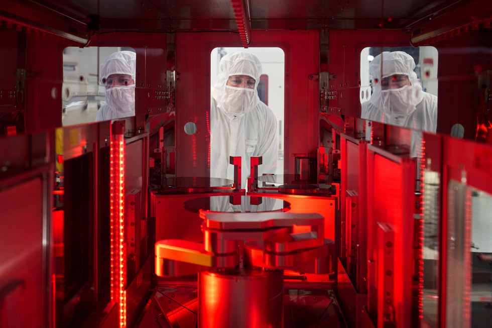 Tres trabajadores con ropa de protección en la planta de fabricación de obleas semiconductoras de Texas Instruments en Lehi, Utah.