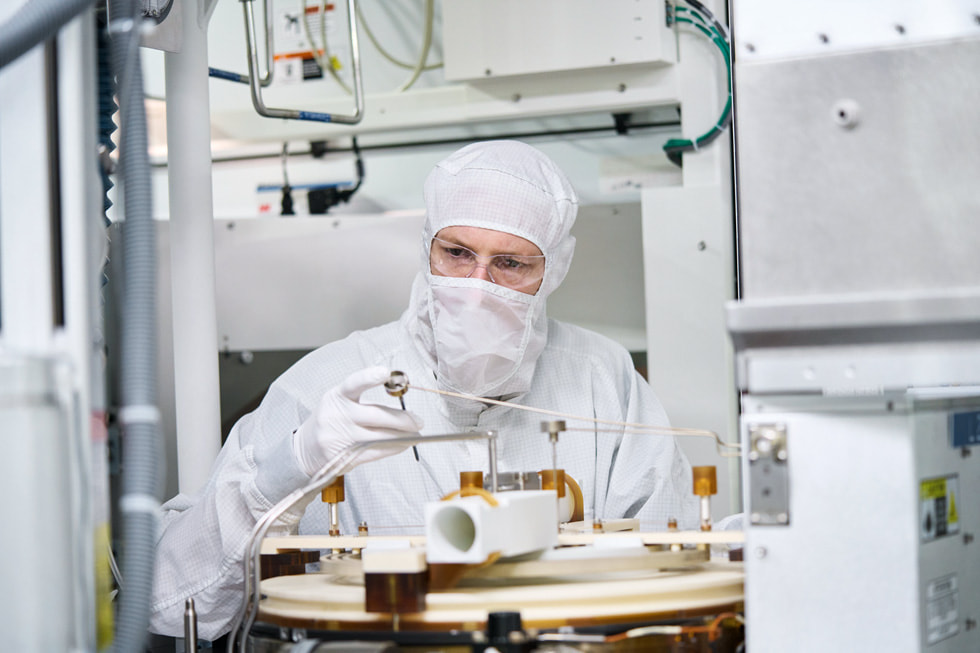 Un trabajador con ropa protectora examina la maquinaria en la planta de fabricación de obleas semiconductoras de Texas Instruments en Lehi, Utah.