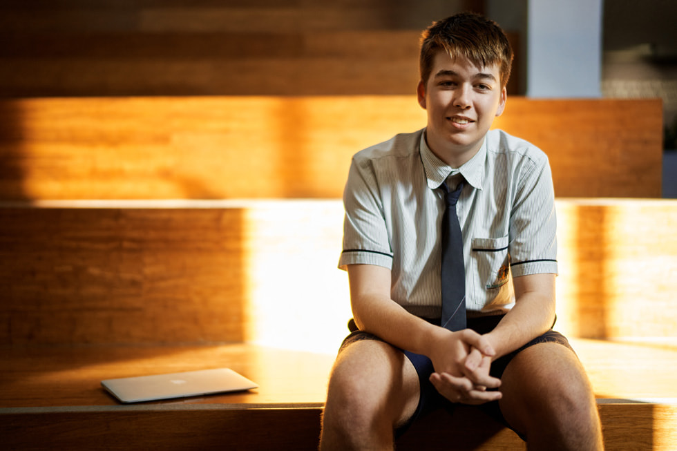 St Augustine’s College’dan Lincoln Hetherington MacBook Air’inin yanında oturuyor.