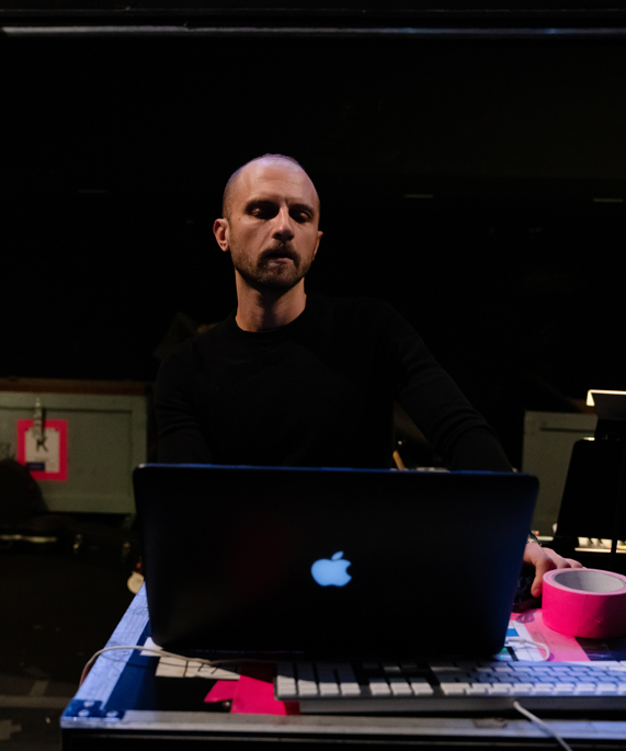Enrico de Trizio bir MacBook Pro’nun arkasında ayakta duruyor. 
